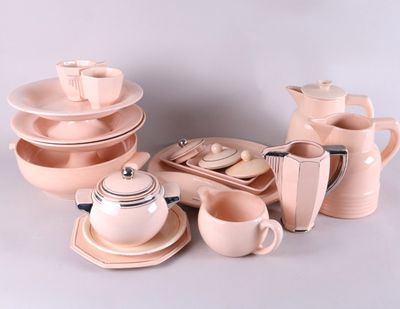 beaucoup d'assiettes et de tasses roses et blanches sur la table