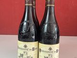 Deux bouteilles de vin sont posées sur un comptoir devant un mur rouge.