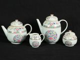four pieces of porcelain tea set on a black background