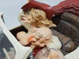 a figurine of a woman sitting in a car