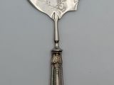 a silver spoon with a silver handle on a white surface