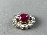 a close up of a ruby and diamond broochle on a table
