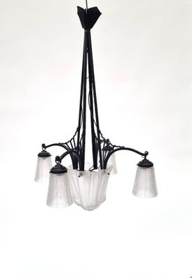 a black chandelier with three glass shades hanging from it