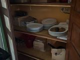 a pantry with a lot of dishes on the shelves