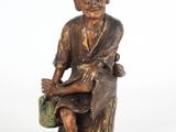 l'image d'une statue d'un homme assis sur un rocher