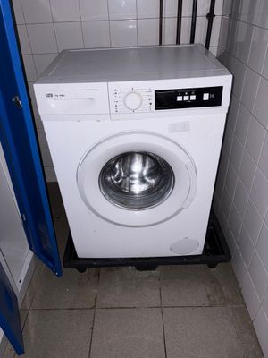 une machine à laver dans un coin d'une petite salle de bains