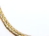 a close up of a gold necklace on a white surface