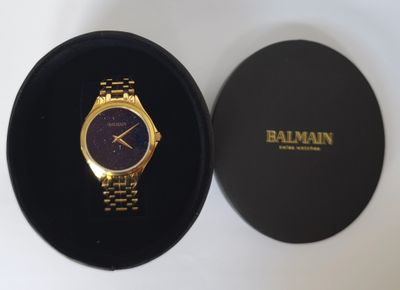une image représentant une montre en or dans un écrin noir posé sur une surface blanche