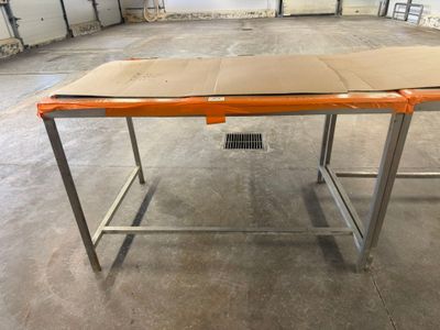 a table with a cardboard box on it in the middle of a warehouse