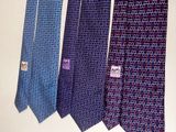 four ties hanging on a wall in a row on a wall