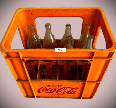 six bouteilles de Coca-Cola dans une caisse en plastique
