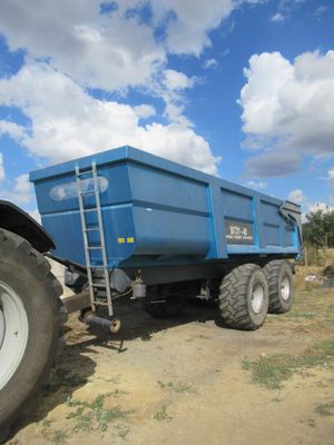 a blue dump truck parked on the side of the road