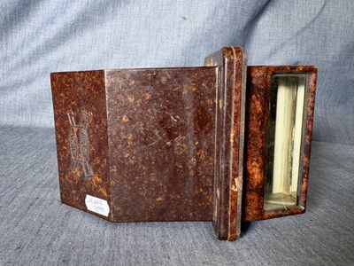 un vieux livre est ouvert sur une surface grise