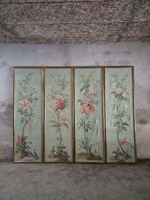 three framed paintings of flowers on a wall in a room