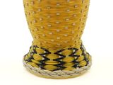 a yellow vase with a black and white design on it