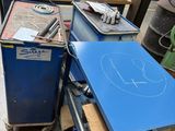 une table bleue sur laquelle est dessiné quelque chose, dans un garage