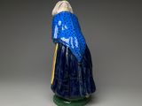 figurine of a woman wearing a blue robe and holding a cane
