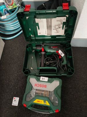 a green tool box with tools in it on the floor