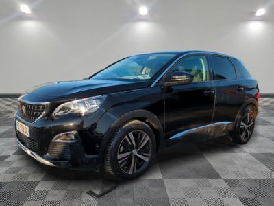une voiture noire est garée dans une pièce au sol en damier
