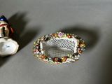 two miniature figurines sitting on a table next to each other