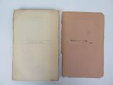 an open book sitting on top of a white table next to a brown book