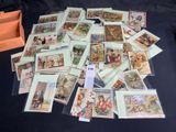 a pile of postcards on a table with a box of them