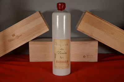 a bottle of alcohol sitting on a table next to two wooden boxes