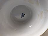 a close up of a white bowl with a blue bird on it