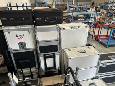 many suitcases stacked on top of each other in a warehouse