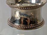 a silver bowl on a glass shelf with a mirror in the background