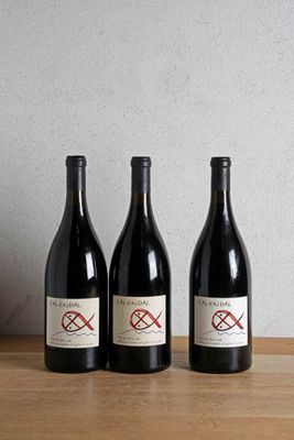 three bottles of wine sitting on top of a wooden table