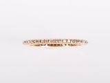 une alliance en or jaune sertie de diamants blancs sur fond blanc