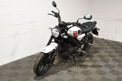 une moto noire et blanche garée dans une pièce