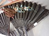 a black fan with flowers on it next to a pair of chopsticks and a pair of scissors