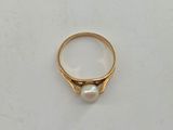 a close up of a gold ring with a pearl in it