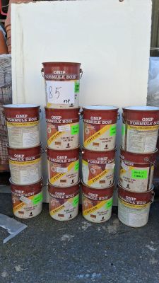 plusieurs seaux remplis de nourriture posés par terre à côté d'une pile de cartons