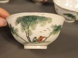 a person holding a small bowl in front of a group of small bowls