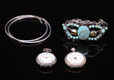 two watches and a bracelet on a black surface
