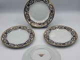 three plates and a saucer are sitting on a table