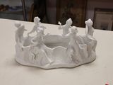 a small white bowl with figurines on it