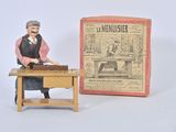 a figurine of a man sitting at a desk in front of a box