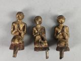 trois figurines en bronze représentant une femme assise sur un tabouret