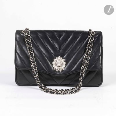 sac à main en cuir noir avec une bandoulière en chaîne et une broche en forme de fleur