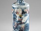 a blue and white vase with a red lid