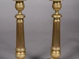 pair of antique brass candlesticks on a grey background