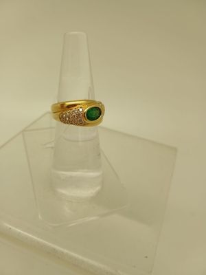 une bague en or surmontée d'une pierre verte
