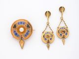 deux paires de boucles d'oreilles et une broche posées sur un fond blanc