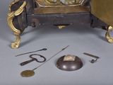 a clock that is sitting on a table next to some tools