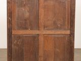 an old wooden cabinet with four doors on top of it