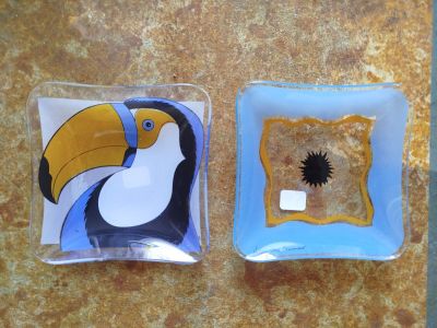 deux assiettes carrées ornées d'un toucan, posées sur une table